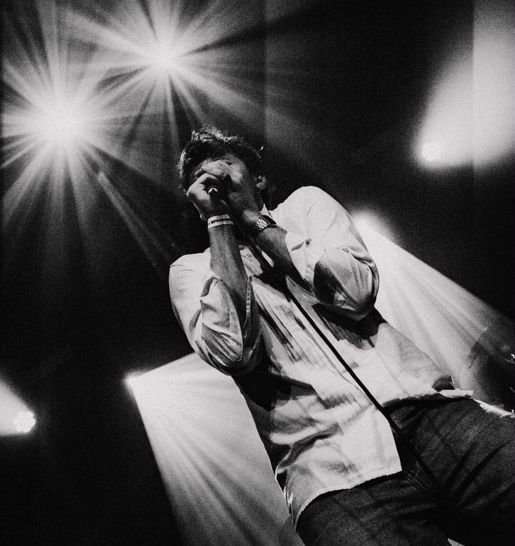 Mauro Edel zingt en speelt gitaar tijdens een optreden in het licht
